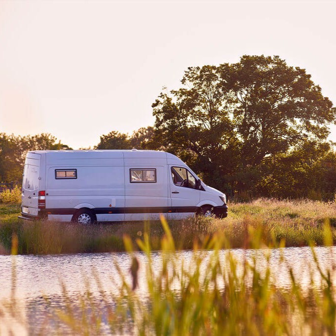 Campervan parked by a river - square